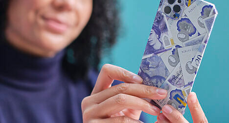 out of focus woman holding a phone covered in origami bank notes