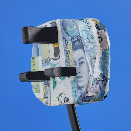 electric plug in origami £5 bank notes against a blue backdrop