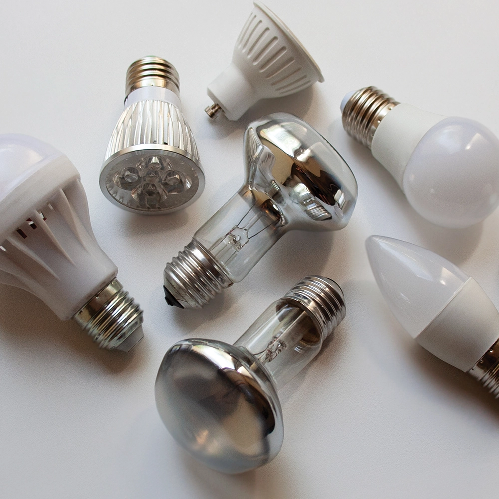 collection of lightbulbs shutterstock_1997395268 a collection of various types of lightbulb on a white table.